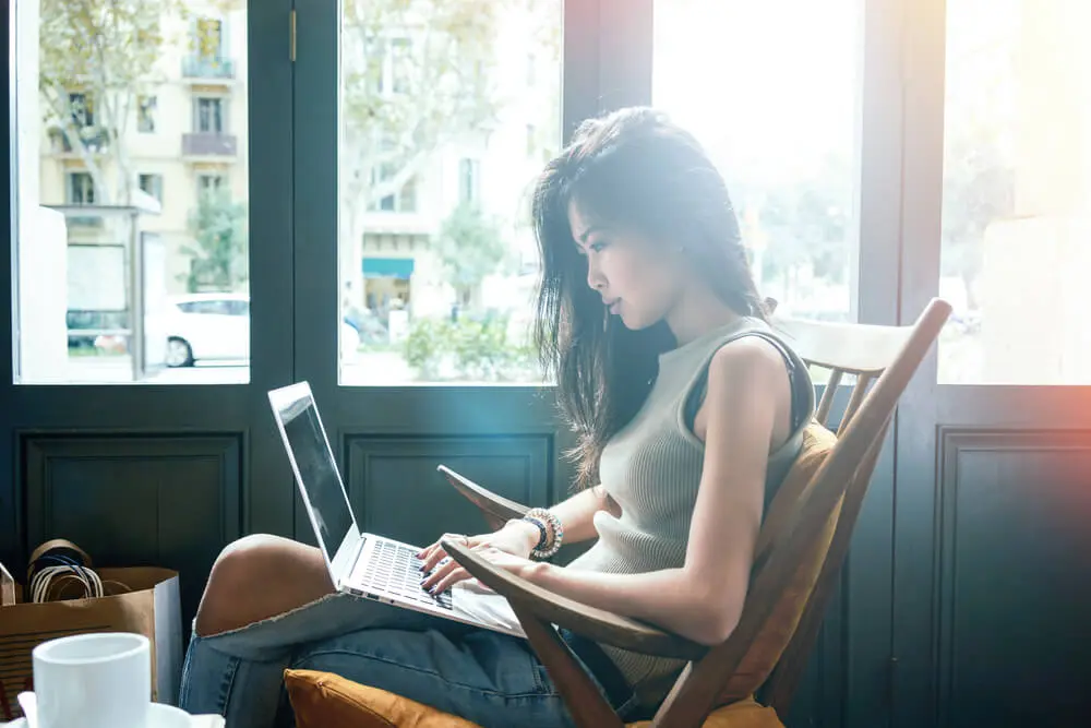 Woman sitting at her computer in an article by Melanie Gorman on how to improve your writing skills.
