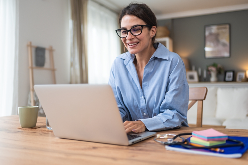 Woman on the computer in an article on YMYL and E-E-A-T scores for therapists who write blogs.