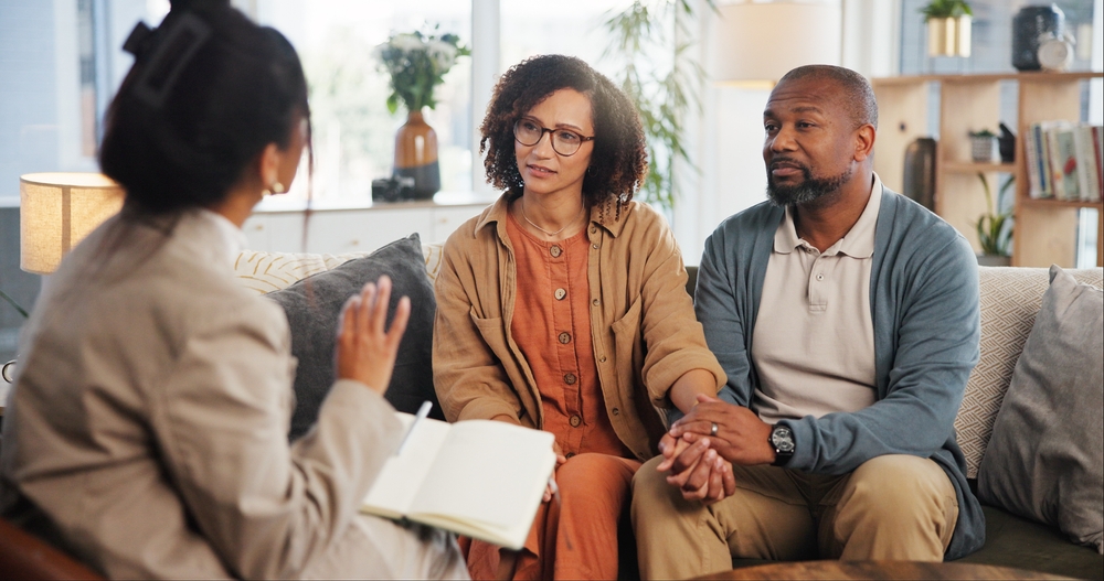 Couple holding hands in a therapy session in an article for therapists about the value of online directories to market their practice.