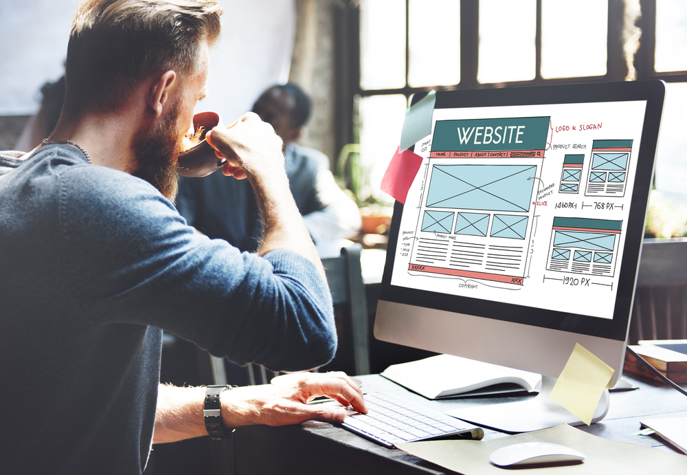 Man sipping coffee in an article on small business websites and what they need to be optimized in 2025.