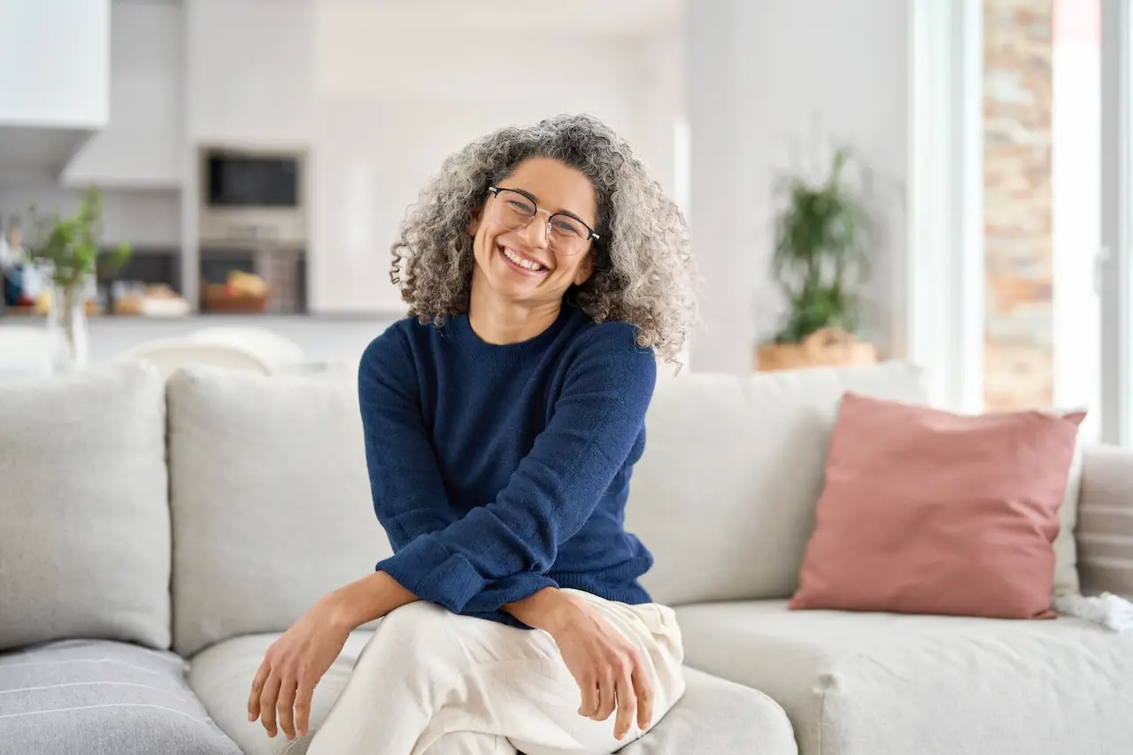Happy woman looking at the camera wearing a blue sweater
