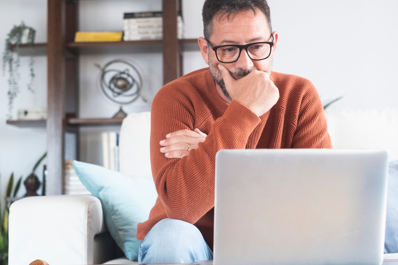| crownsville media - seo, ai visibility & digital marketing for small business owners A therapist looking at his laptop screen trying to create content with an seo focus