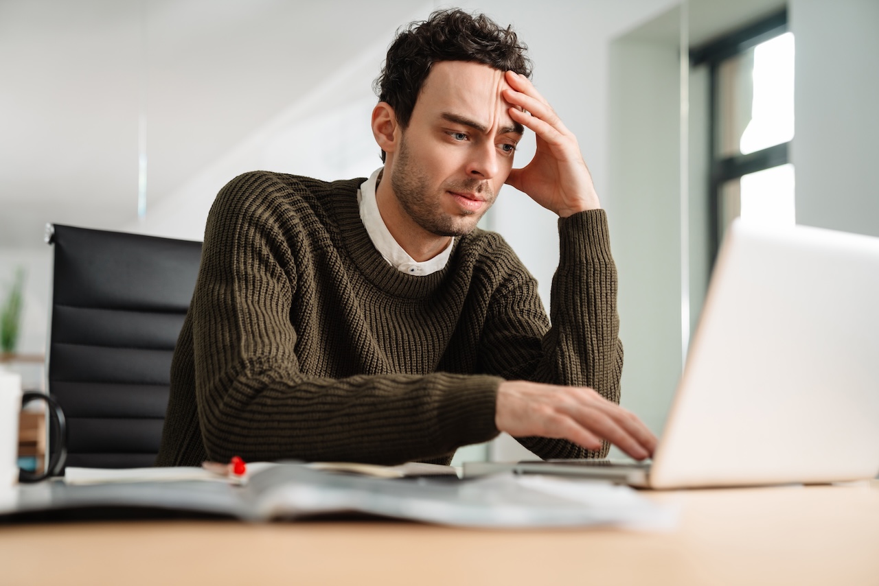 Stressed business man looking at laptop | crownsville media - seo, ai visibility & digital marketing for small business owners Stressed business man looking at laptop wondering how to write content with an seo focus