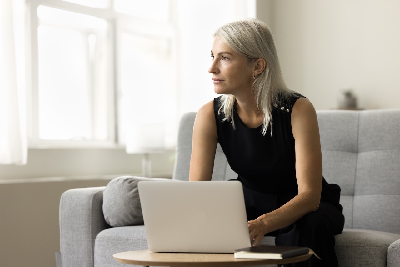| crownsville media - seo, ai visibility & digital marketing for small business owners Serious thoughtful mature business owner trying to write content with an seo focus working at home on her laptop